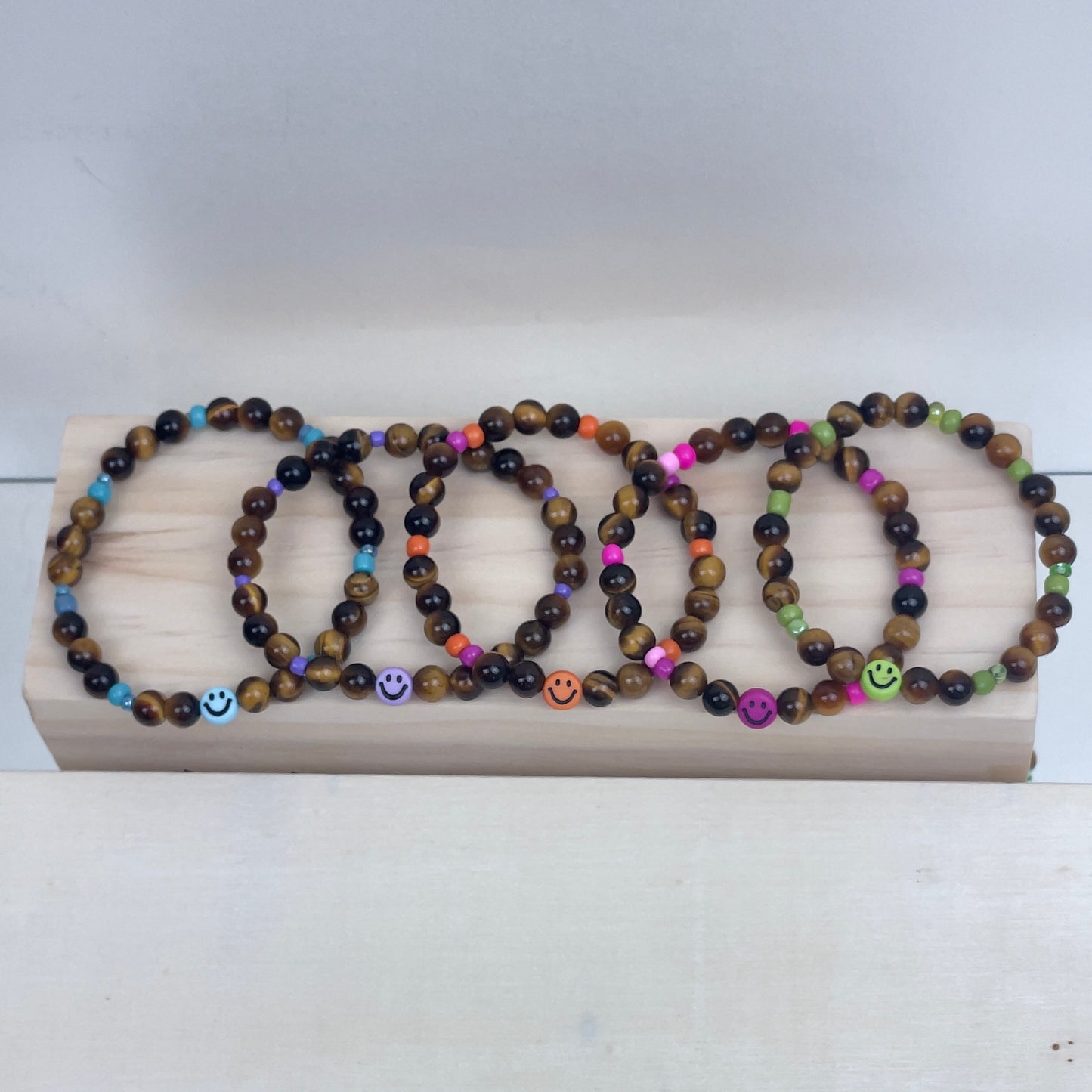 Armband Tigerauge „Mutmacher“ Kinder-Edition mit 6 mm Perlen und fröhlichem Gesicht